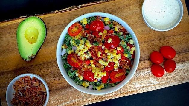 Columbus · Shredded kale, cherry tomato, house-roasted corn, red pepper, red onion, smoky bacon pieces, avocado, housemade buttermilk Parmesan dressing.