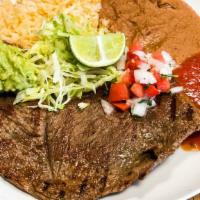 Carne Asada · This plate is served with rice, refried  beans, guac, salsa, lettuce, pico de Gallo, lime an...
