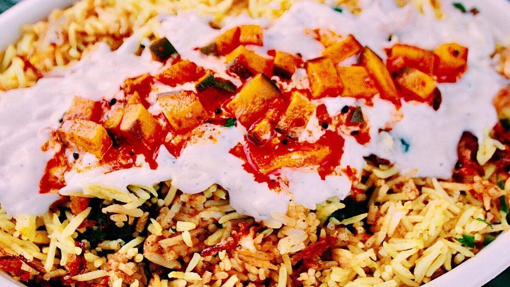 Chicken Biryani · Flavored basmati rice cooked with special spices and topped with golden fried onions and mint.