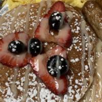 Pancakes · 3 cakes topped with mixed berries, whip cream cheese, & caramel glaze served with 2 sides