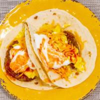 Breakfast Taco · Two 6” tacos with two scrambled eggs, cheddar cheese, sausage, sour cream, and hot sauce