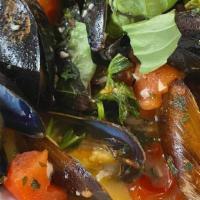 Steamed Mussels · in a white wine broth with garlic, and tomato served over crostini.