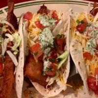 Baja Fish Tacos · Battered cod fillets, topped with shredded cabbage, Monterey jack and cheddar cheese, pico a...
