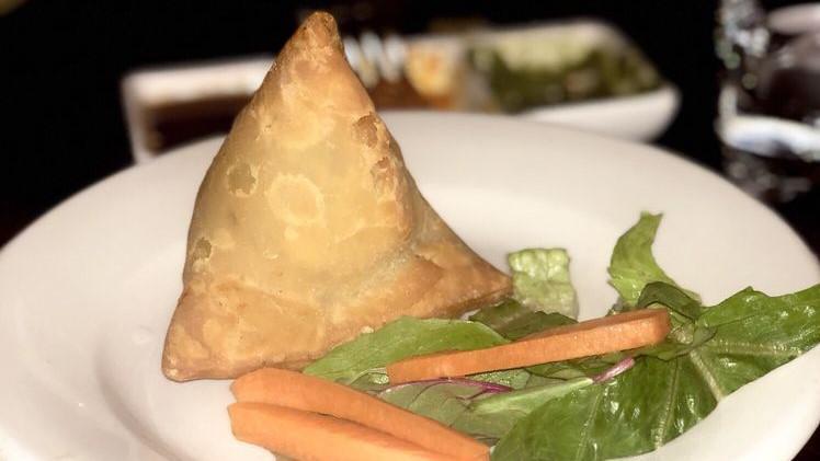 Vegetable Samosa · Vegetarian. Deep fried pastry triangle stuffed with spiced potatoes and peas.