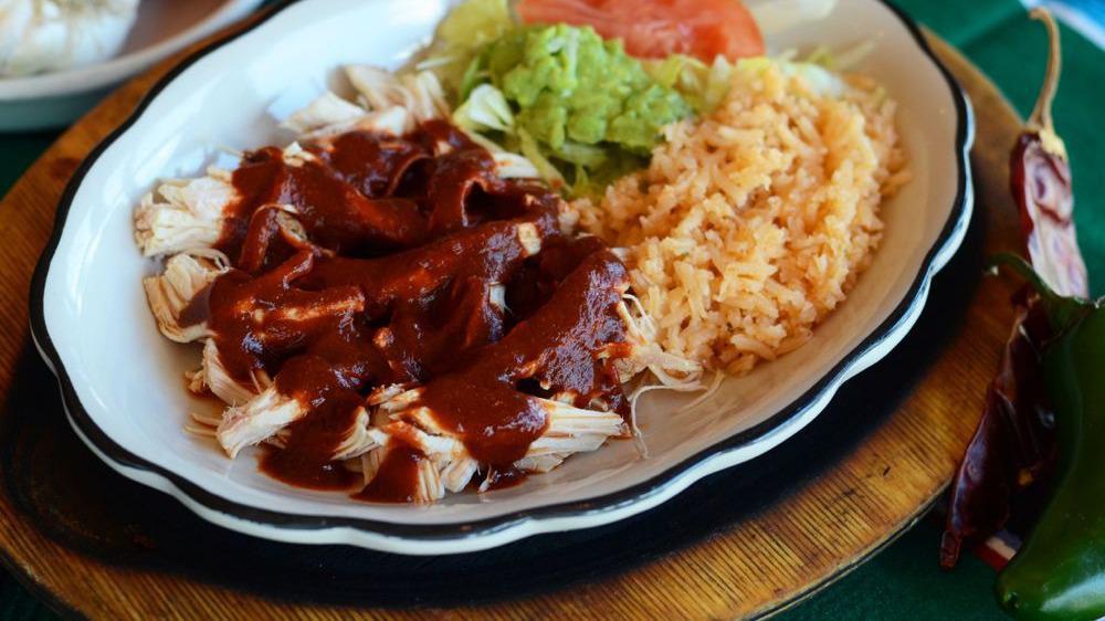 Mole Ranchero (Spicy) · Shredded Chicken drenched in our Ranchero Mole sauce. Served with Guacamole Salad, Spanish Rice, and Tortillas