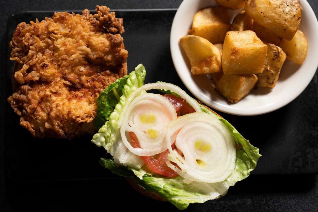 Fried Chicken Sandwich · Marinated in Buttermilk and Spices, served on a homemade Brioche Bun with Lettuce, Tomato, Onion, Cornichons, & Herb Mayonnaise, served with a side of Roasted Potatoes