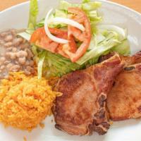 Chuleta Ahumada De Puerco · Smoked pork chops. Served with rice, beans, fried onion, jalapeños and salad.