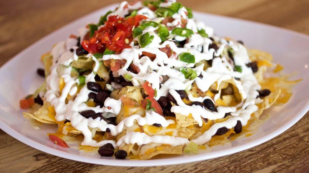 Nachos · Crispy corn tortilla chips covered with melted cheese, your choice of beans, lettuce, fresh salsa, jalapeno, sour cream, and your choice of protein.