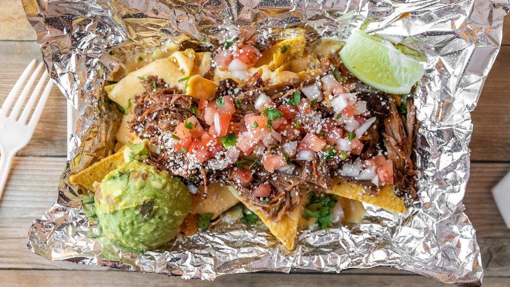 Nacho Bowl · A heaping mound of tortilla chips topped with our house made queso, fresh pico de gallo, guacamole, cilantro, choice of meat, and a lime. Queso is served on the side to preserve freshness.