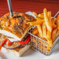 Eggplant Muffuletta Sandwich · Eggplant cooked on our flat top grill with pesto, roasted red peppers, olive tapenade, and f...