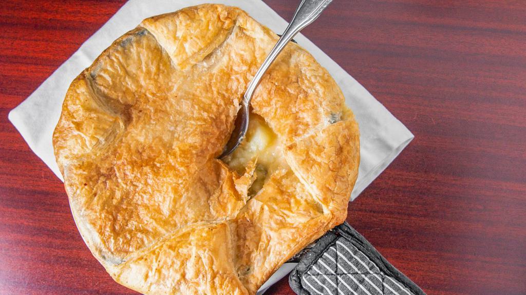 Chicken Pot Pie (Individual Size) · Tender braised chicken with carrots, celery, onions and please in a savory gravy, topped with puff pastry and backed to golden brown. Served in a cast iron skillet.