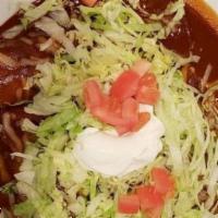 Enchiladas Poblanas · 3 chicken Enchiladas, stuffed with chicken & topped with mole poblano sauce, lettuce, tomato...