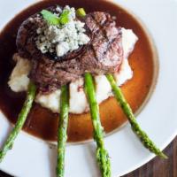 Char-Grilled Filet Mignon · With crumbled gorgonzola cheese, red onion, confit, asparagus, currant demi, and roasted gar...