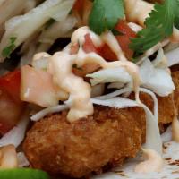 Crispy Fish Soft Tacos · 2 Soft Tacos filled with Crispy Fish, slaw, & Yum Yum sauce on a soft sandwich roll with a s...