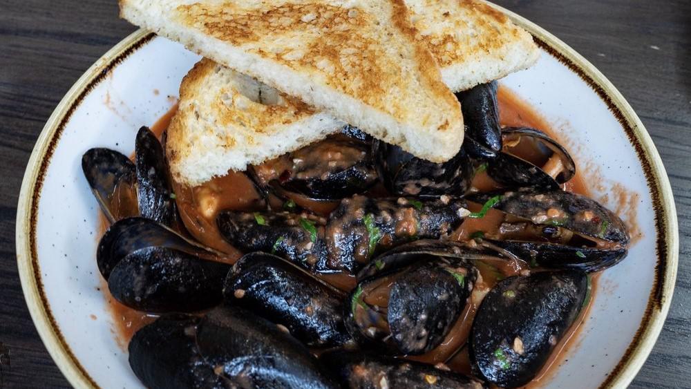 Diablo Mussels · tomatoes, onions, chiles, andouille sausage served with sourdough.