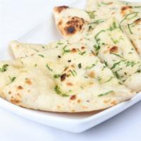 Garlic And Coriander Naan · Indian flatbread made from white mix flour, cooked in a traditional tandoor oven and garnish...