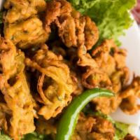 Onion Pakora · Freshly sliced onions dipped in chickpea batter and deep fried to golden crisp.
