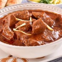 Goat Curry · Goat (with bone) marinated and cooked in onion and tomato flavored stew with aromatic spices.