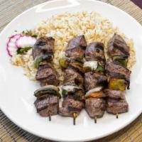 Beef Kebab · Two skewers of marinated beef tenderloin grilled over an open flame served with rice pilaf