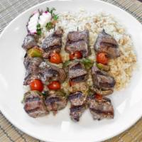 Lamb Kebab · Two skewers of charbroiled marinated lamb grilled over an open flame served with rice pilaf