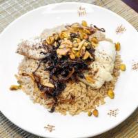 Sayadieh Bi Samak · Baked haddock filet served over spiced rice topped with tahini sauce, caramelized onions and...