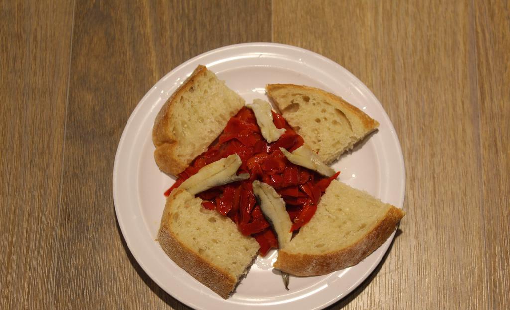 Crostini · With roasted red peppers, white anchovies marinated in white wine, bread.