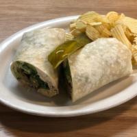 Falafel Wrap · A traditional falafel wrap with tabbouleh, hummus, feta,. lettuce, and tzatziki in a warm fl...