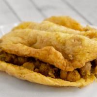 Doubles · Sandwich made with two bara (flat fried bread) filled with chana. Topped with mango, shadon ...