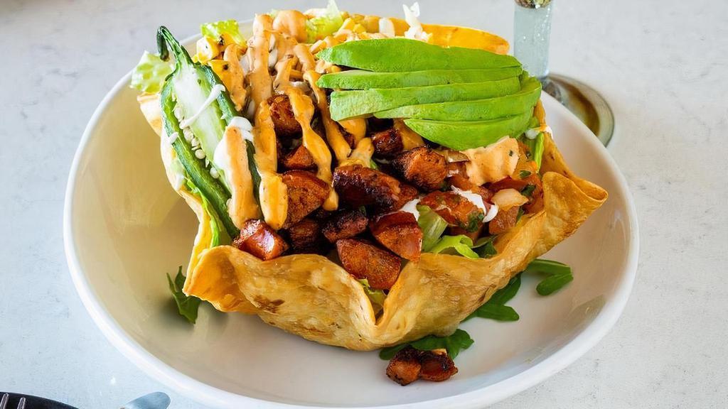Taco Salad · Crispy Tortilla bowl, shredded lettuce, chipotle aioli, corn, pico de gallo, jalapeño, avocado, chorizo sour cream, and shredded cheese.