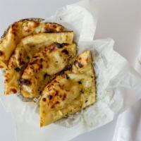 Garlic Naan · Unleavened, handmade bread stuffed with fresh garlic and cilantro.