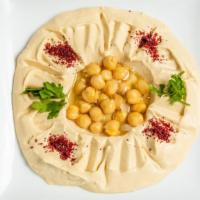 Hummus · Chickpeas mixed with tahini sauce, lemon juice and served with pita bread chips.