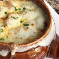 French Onion Soup · Sweet onions and crostini, under a blanket of perfectly melted gruyere cheese.