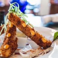 Rollos Costenos · Lightly breaded flour tortilla stuffed with chihuahua cheese, braised poblano peppers, lump ...