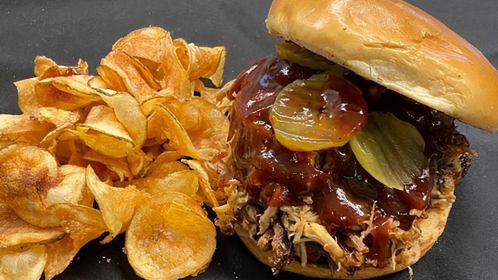 Pulled Pork Sandwich · Smoked pulled pork, BBQ sauce, and pickles on a brioche bun. Served with our house chips.