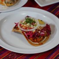 Enchiladas Guatemaltecas · Open face crispy corn tortilla topped with mixed vegetables and chicken, beets, cabbage, tom...