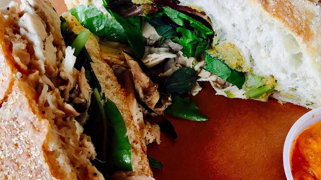 The Lyon · CIABATTA, WHITE BEAN PUREE, OLIVE TAPENADE, PULLED CHICKEN, GREENS, ROASTED PEPPER SAUCE