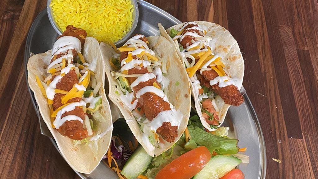 Buffalo Chicken Tacos · Crispy fried chicken Tossed in Buffalo sauce served over lettuce, pico de gallo, cheddar cheese & topped with buttermilk ranch. served with rice & salad.