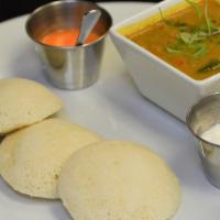 Idli Sambar · Steamed rice cakes served with tomato, coconut chutney, lentil and vegetable stew.