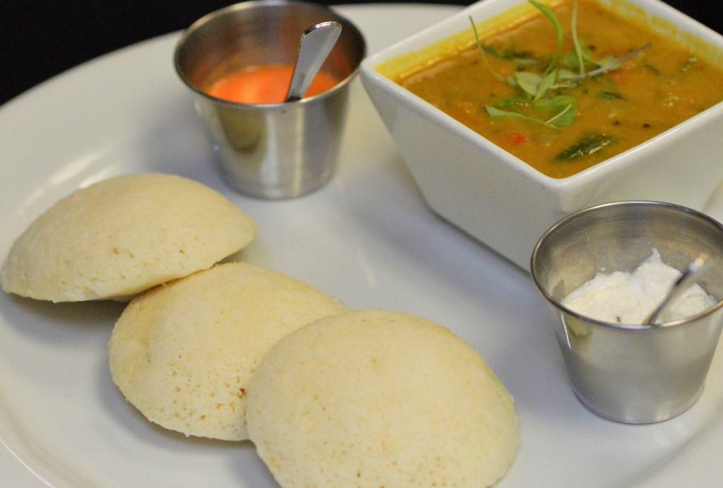 Idli Sambar · Steamed rice cakes served with tomato, coconut chutney, lentil and vegetable stew.