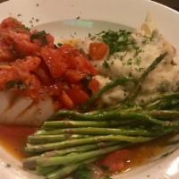 Pesce Bianco - Baked Haddock · Baked haddock with a champagne plum tomato garlic butter sauce and basil served with mashed ...