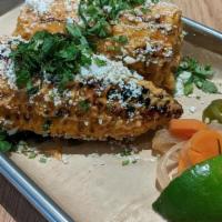 Elote · One whole ear of Mexican grilled street corn smothered in chipotle aioli, cilantro, and coti...