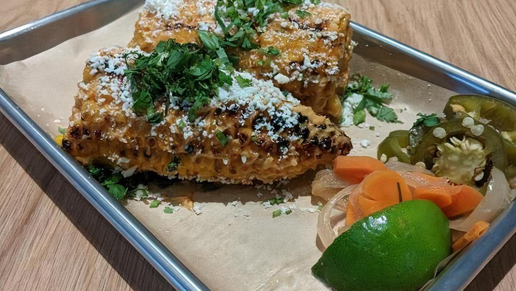 Elote · One whole ear of Mexican grilled street corn smothered in chipotle aioli, cilantro, and cotija cheese.