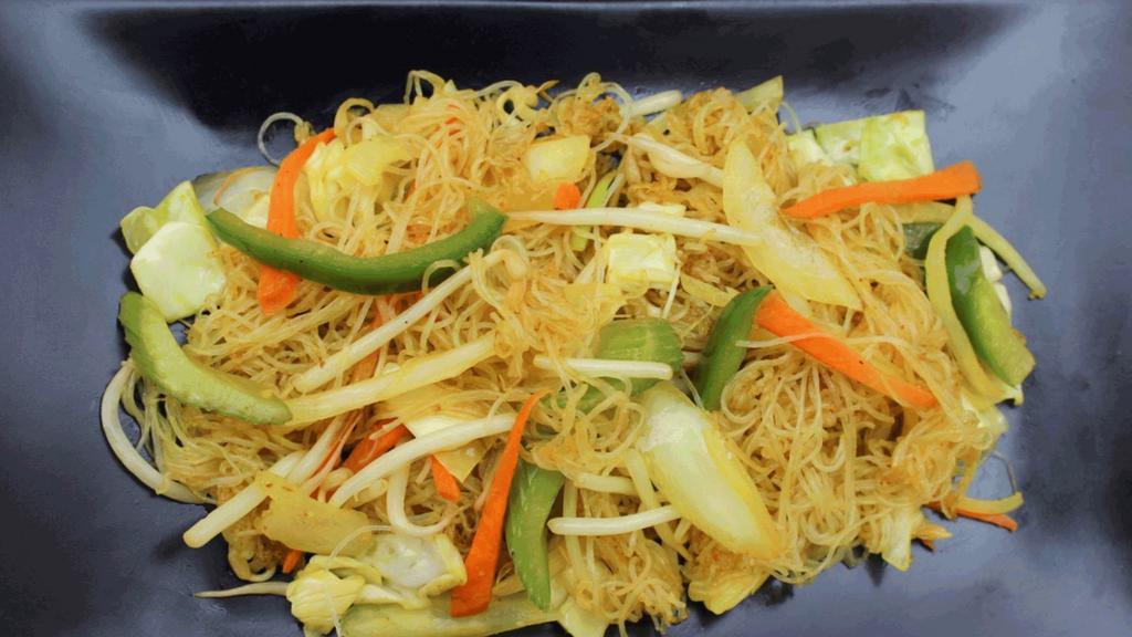 Singapore Noodles · Stir fried thin rice vermicelli noodles with bell peppers, onions, carrots, bean sprouts, and celery in a yellow curry.