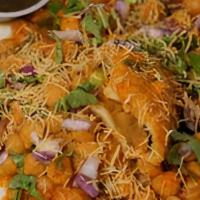 Samosa Chaat · Two crispy vegetable turnovers topped with chickpeas, spiced onion and chutney