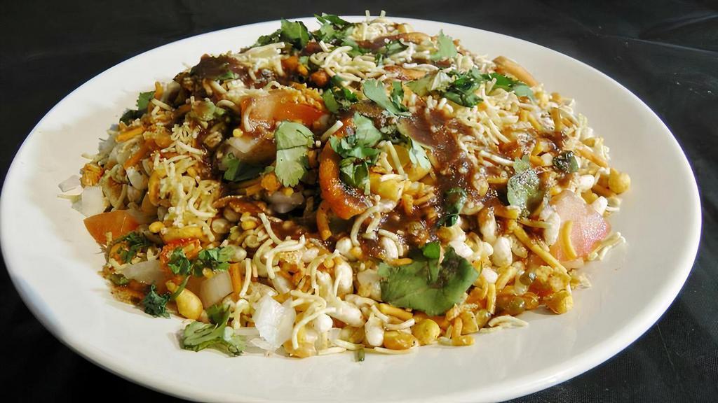Bhel Puri · Puffed rice and flour chips topped with seasoned onions, cilantro, diced potatoes and chutney