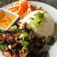 Grilled Pork With Rice · Pork marinated with lemongrass then grilled and served over rice. Served with sliced cucumbe...