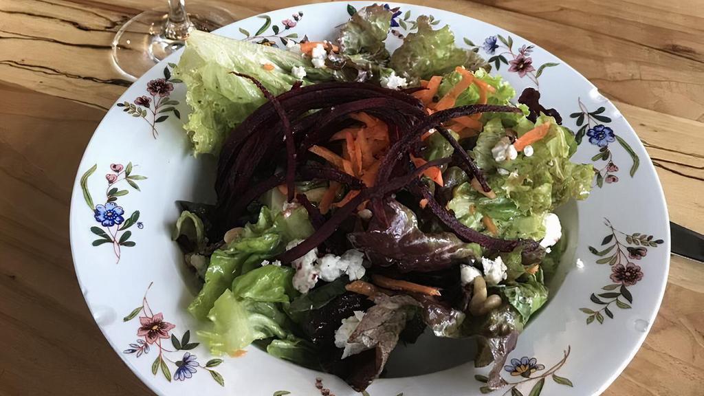 Beet Salad · Organic greens mix, beets, carrots, crumbled goat cheese, shaved almonds, basil vinaigrette.