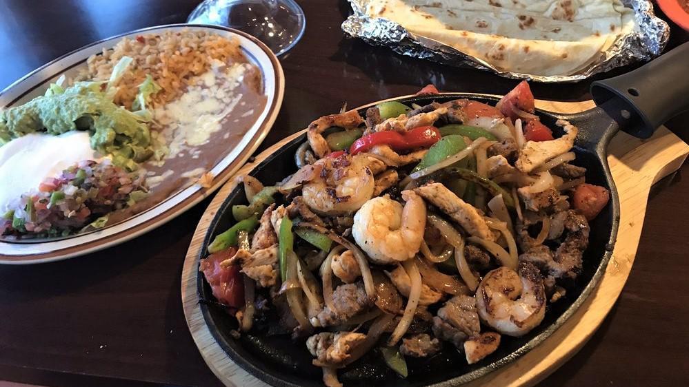 Fajitas Mazatlan · Grilled shrimp, scallops, crab, tilapia fish fillet, mushrooms, onions, bell peppers & tomatoes, cooked to perfection, served with guacamole salad, pico de gallo, sour cream, refried beans and Spanish rice.