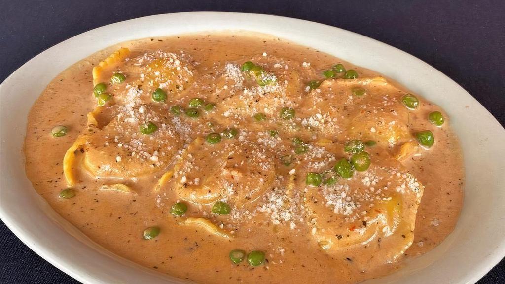 Seafood Ravioli Mario · Filled with shrimp, scallops and lobster in a sherry wine sauce with roasted tomatoes, peas and fresh herbs with romano cheese