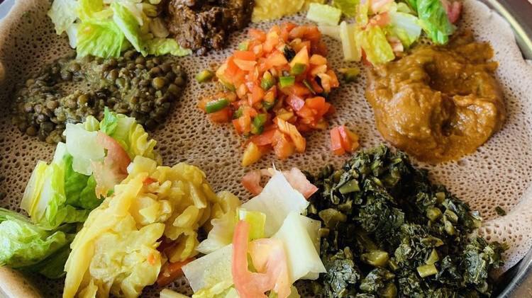 Veggie Combo · Our vegetarian platter served with red lentils, yellow split peas, cabbage and tomato salad, collard greens, and shiro.